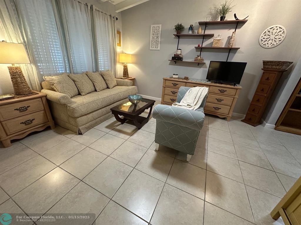 1605 Southwest 25th Street, Unit 4 Fort Lauderdale, FL 33315 - Photo 2 of 14 a living room with furniture a flat screen tv and a window
