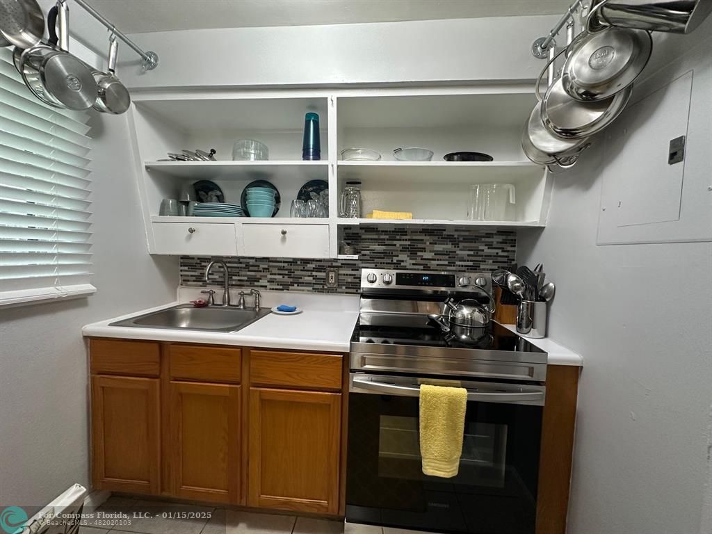 1605 Southwest 25th Street, Unit 4 Fort Lauderdale, FL 33315 - Photo 6 of 14 a kitchen with a stove and cabinets