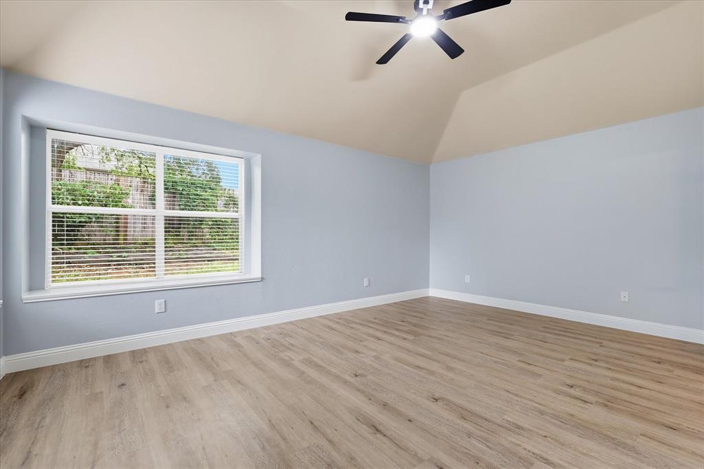 2616 Hollow Ridge Drive Denton, TX 76210 - Photo 18 of 31 Vaulted ceiling featuring a ceiling fan with integrated lighting, wood-finish flooring, and light blue walls with white baseboards