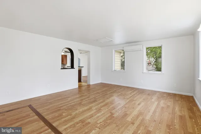 a view of empty room with wooden floor