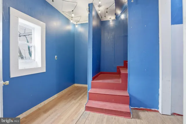 a view of a hallway with wooden floor and staircase