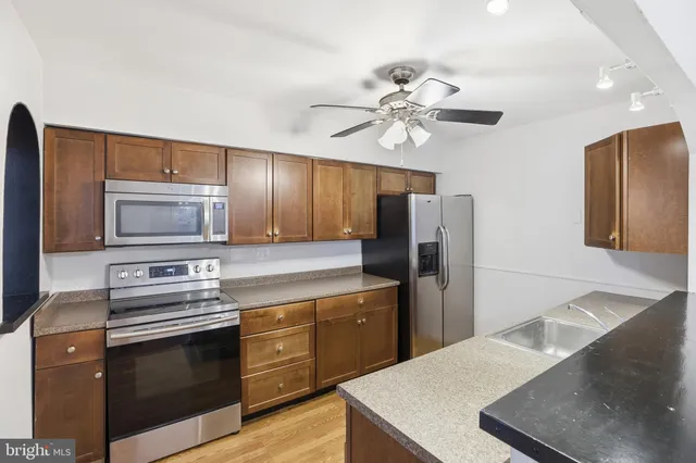 a kitchen with stainless steel appliances a stove microwave and refrigerator