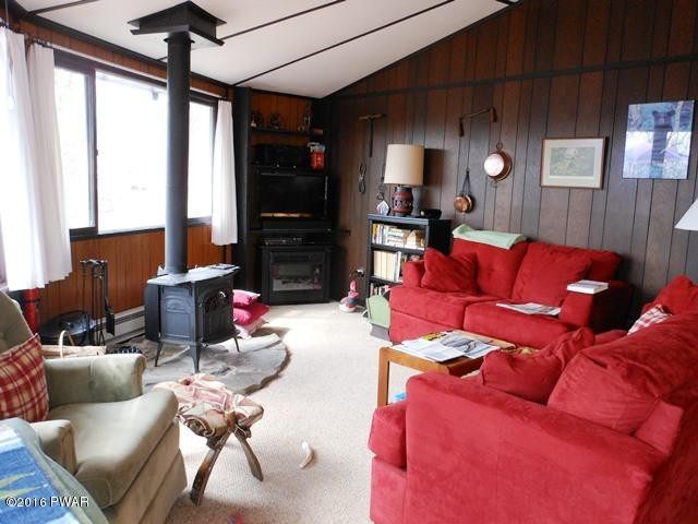 105 Ridge Road Hawley, PA 18428 - Photo 2 of 41 a living room with furniture a flat screen tv and a floor to ceiling window