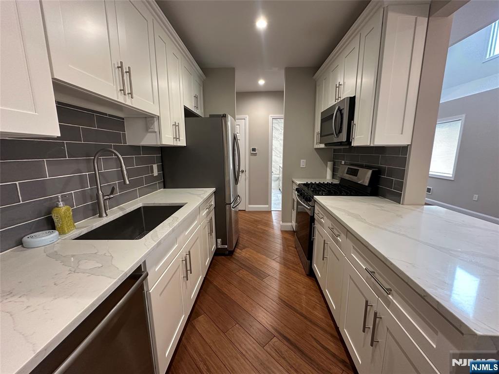 a kitchen with stainless steel appliances a sink stove and refrigerator