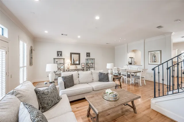 a living room with furniture and a dining table with wooden floor