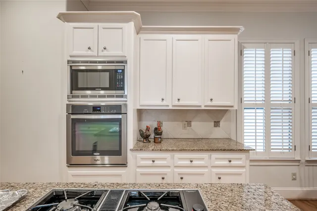 a kitchen with white cabinets and appliances