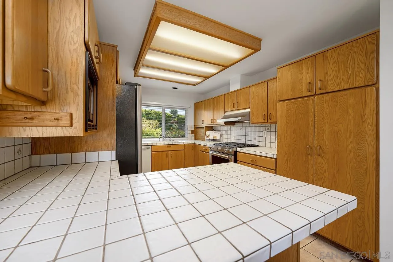 2711 South Barcelona Street Spring Valley, CA 91977 - Photo 8 of 38 a large white kitchen with a sink and cabinets