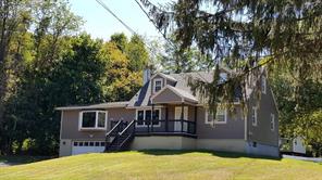 a front view of a house with yard and tree s