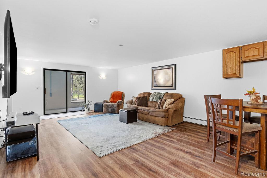 8742 Hyne Road Brighton, MI 48114 - Photo 36 of 65 Living room featuring light wood finished floors and a baseboard radiator