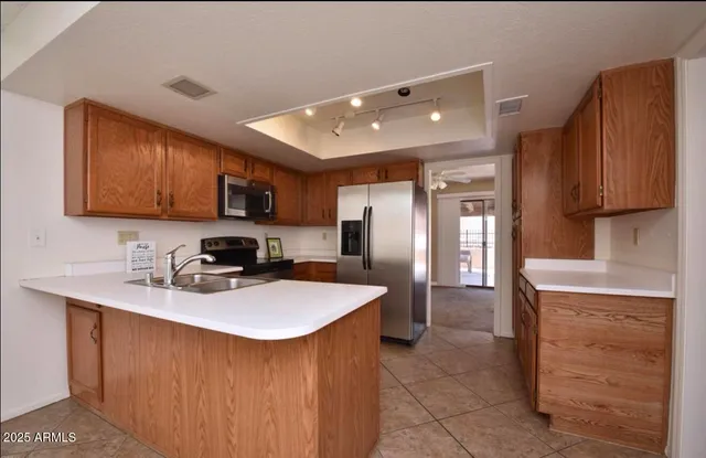 a kitchen with stainless steel appliances granite countertop a sink stove refrigerator and cabinets
