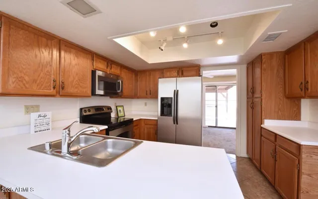 a kitchen with stainless steel appliances granite countertop a sink refrigerator and microwave