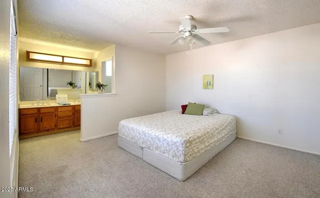 a spacious bedroom with a bed and a chandelier