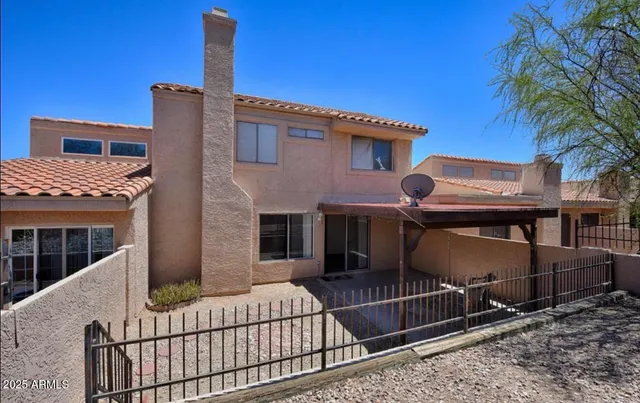 a side view of a house with iron fence