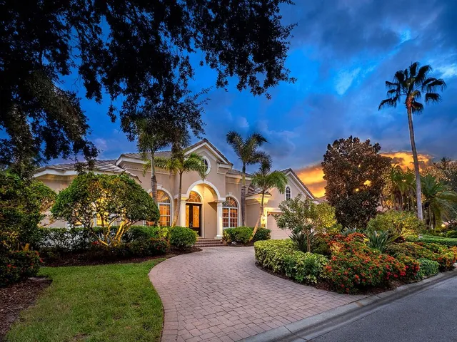 a view of a house with a yard and potted plants