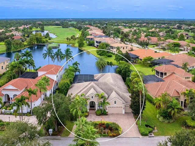 an aerial view of residential houses with outdoor space and lake view