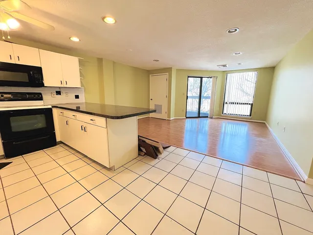 a kitchen with stainless steel appliances a stove a sink and white cabinets