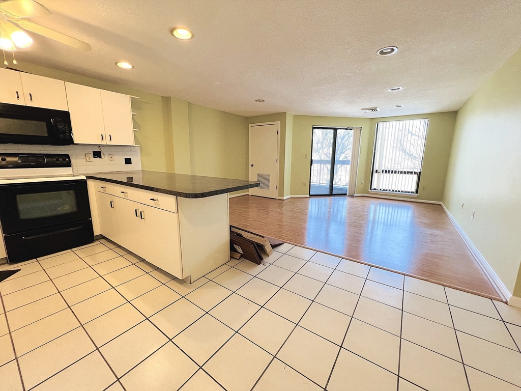 a kitchen with stainless steel appliances a stove a sink and white cabinets