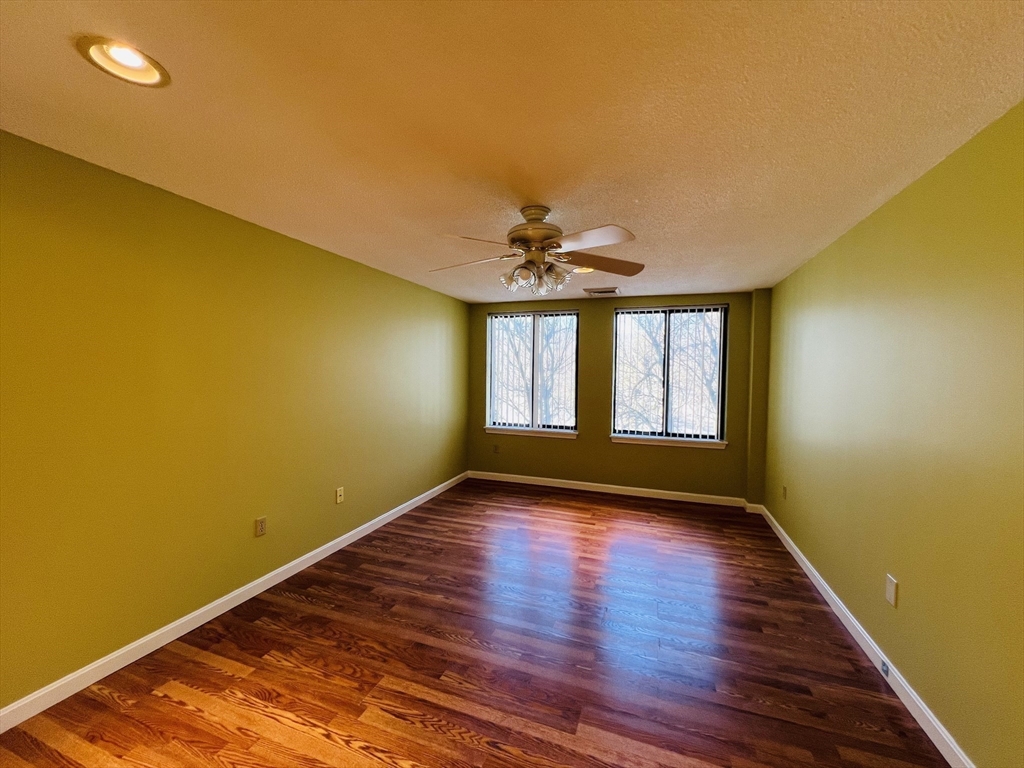 65 Valley Street, Unit 4F Medford, MA 02155 - Photo 11 of 15 a view of an empty room with wooden floor and a window