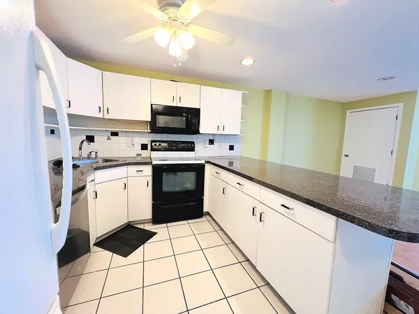 a kitchen with a sink a stove cabinets and stainless steel appliances