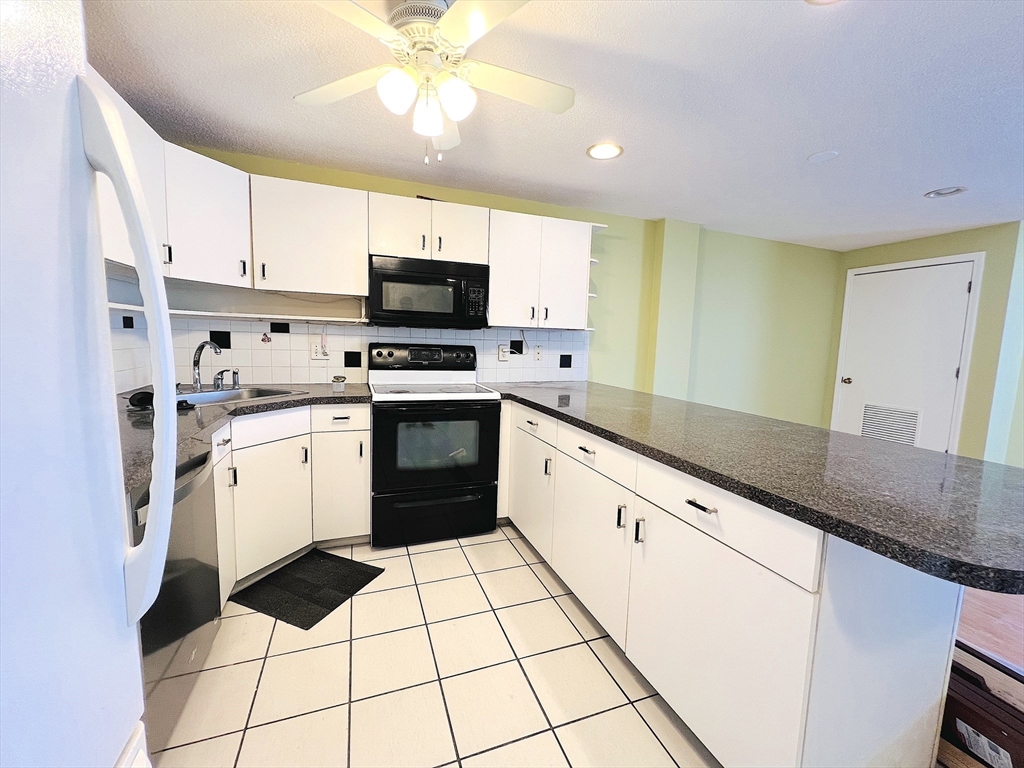 65 Valley Street, Unit 4F Medford, MA 02155 - Photo 2 of 15 a kitchen with a sink a stove cabinets and stainless steel appliances