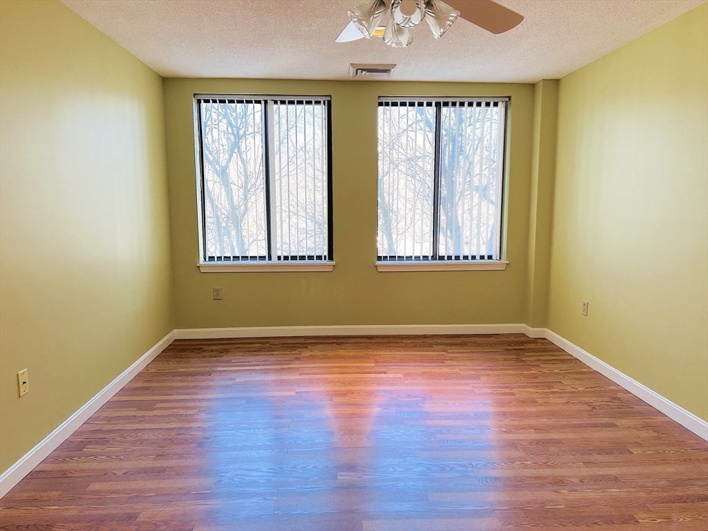 65 Valley Street, Unit 4F Medford, MA 02155 - Photo 6 of 15 a view of an empty room with wooden floor and a window
