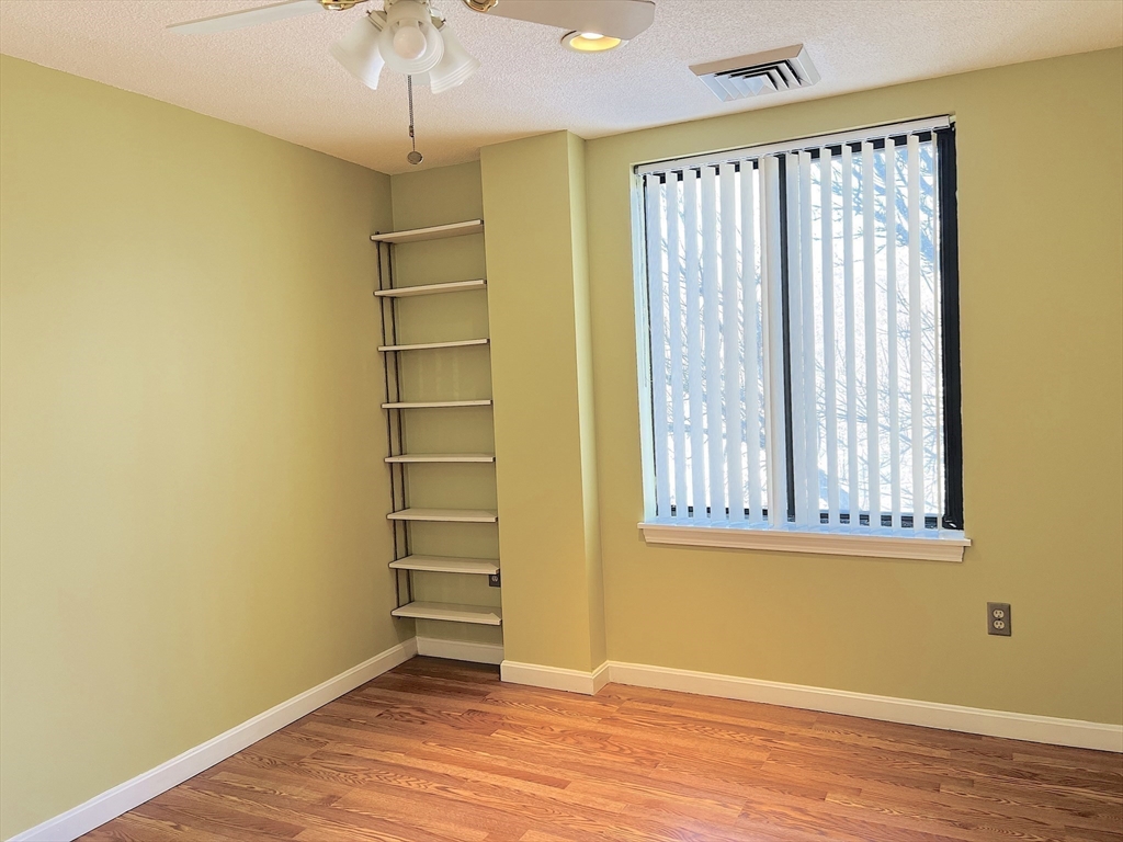 65 Valley Street, Unit 4F Medford, MA 02155 - Photo 7 of 15 an empty room with a windows and chandelier fan