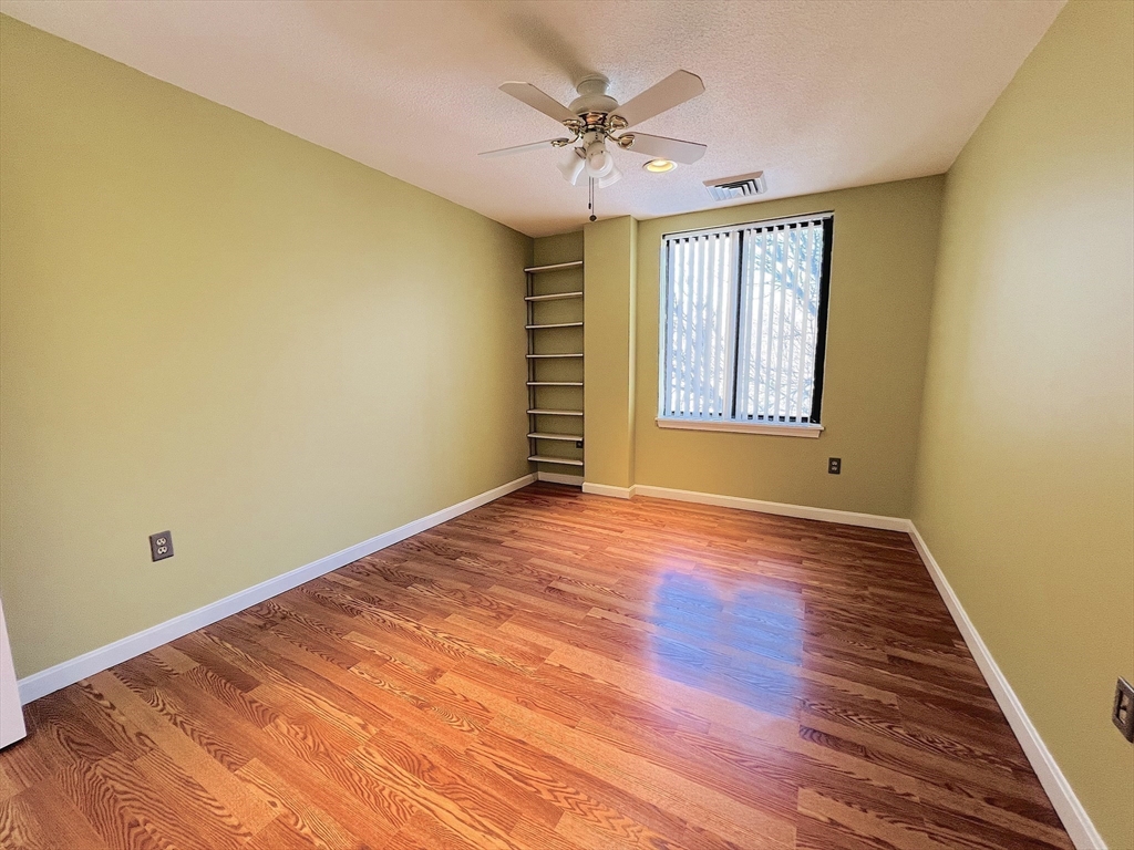 65 Valley Street, Unit 4F Medford, MA 02155 - Photo 9 of 15 a view of an empty room with a window and wooden floor