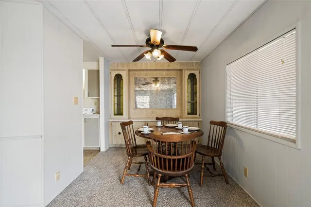 a dining room with furniture a chandelier and window