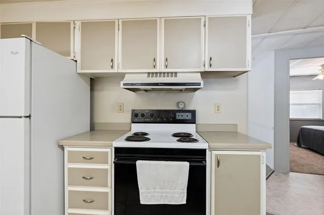 a kitchen with granite countertop white cabinets and white appliances
