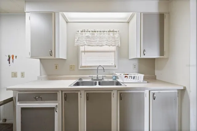 a kitchen with stainless steel appliances granite countertop a sink stove and white cabinets