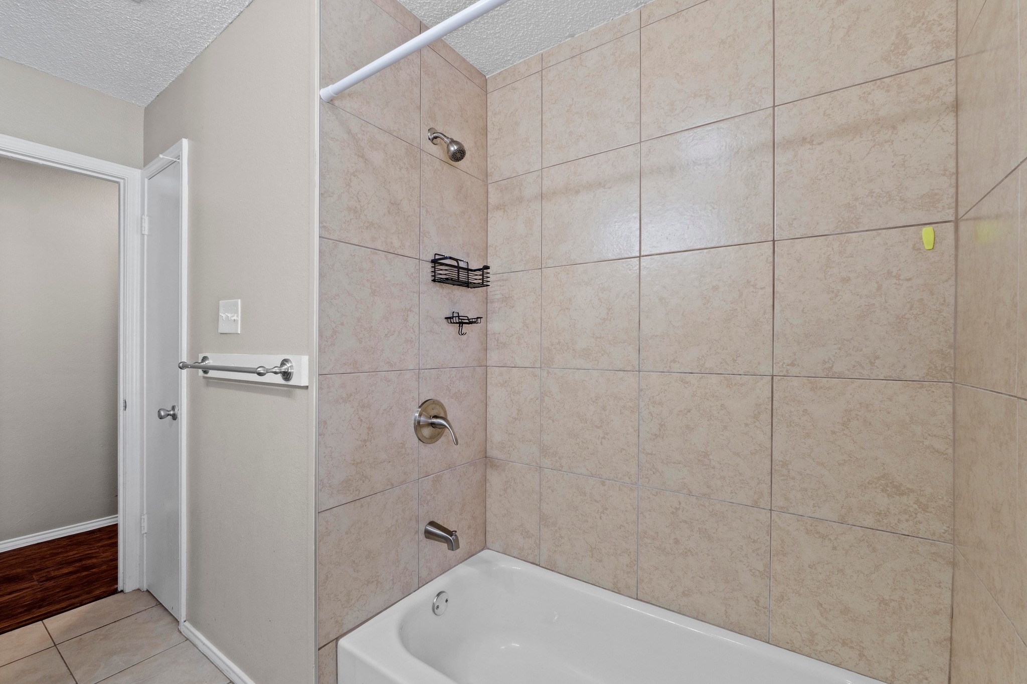 4208 Duval Road, Unit C Austin, TX 78759 - Photo 21 of 28 Bathroom with a textured ceiling, washtub / shower combination, and tile patterned flooring
