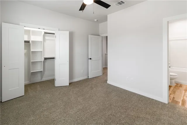 an empty room with a ceiling fan and window