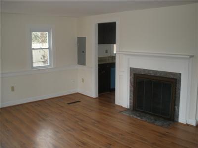 137 Baxter Road Hyannis, MA 02601 - Photo 5 of 9 an empty room with wooden floor fireplace and windows