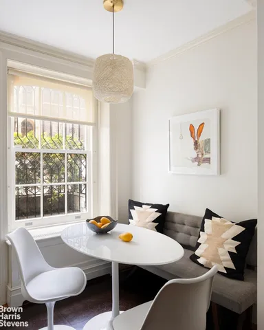 a dining room with furniture a kitchen view and wooden floor