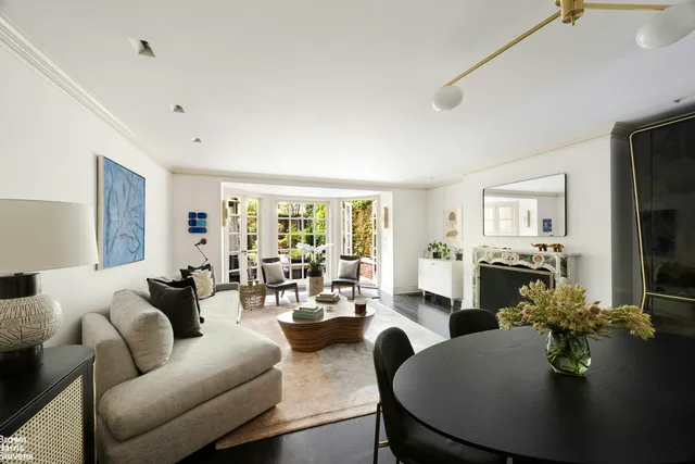 a living room with furniture large window and wooden floor