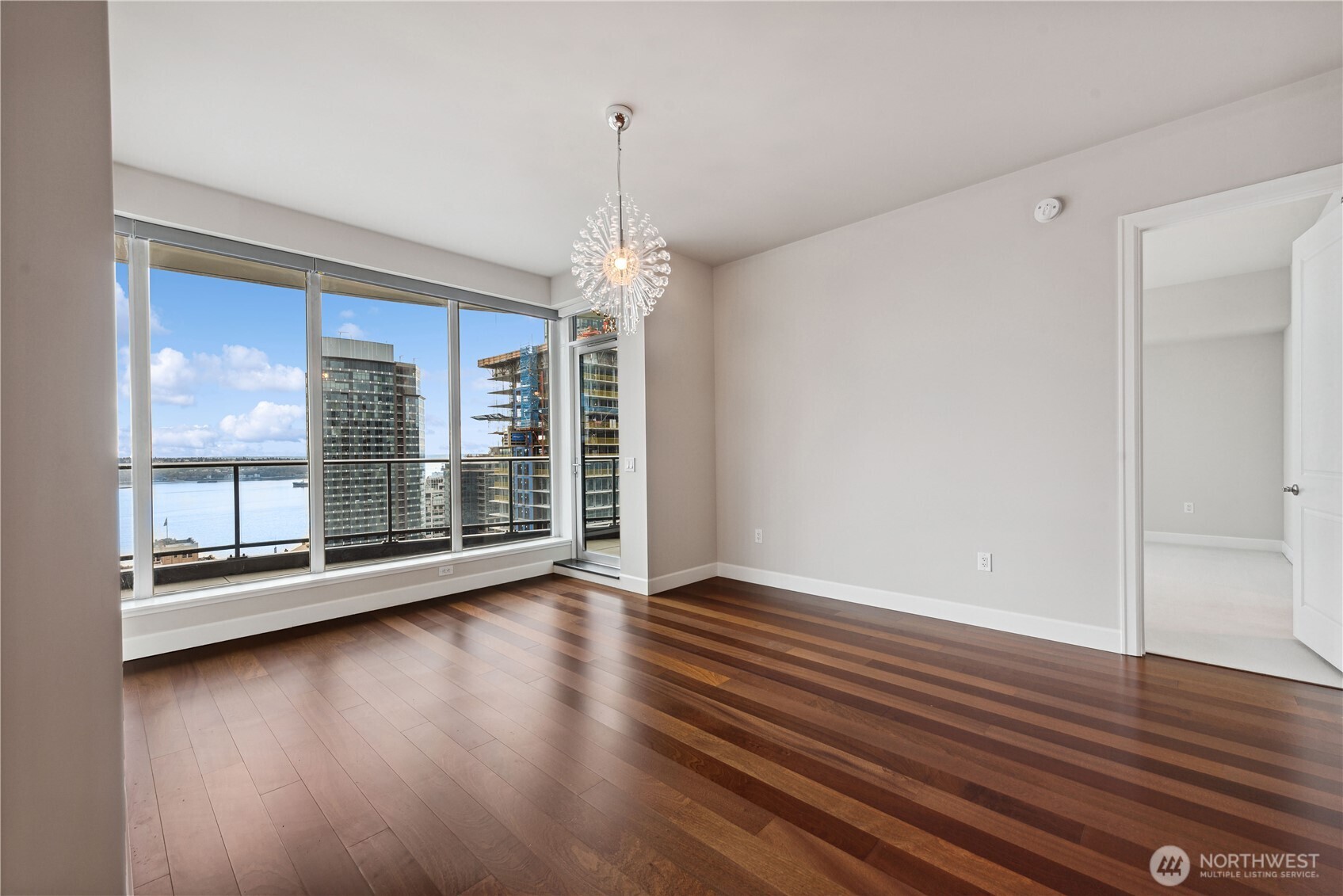 1920 4th Avenue, Unit 2702 Seattle, WA 98101 - Photo 11 of 40 a view of an empty room with wooden floor and a window