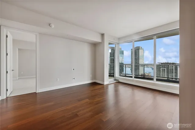an empty room with wooden floor and windows