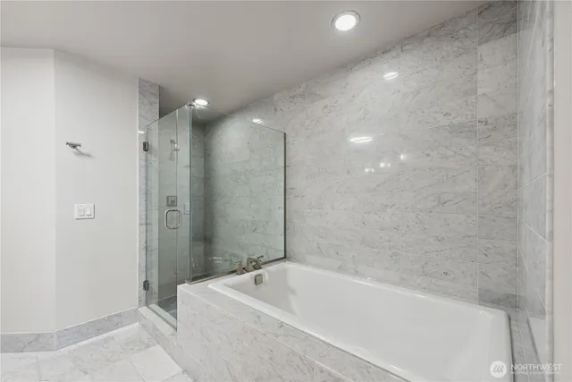 a bathroom with a tub a sink and shower