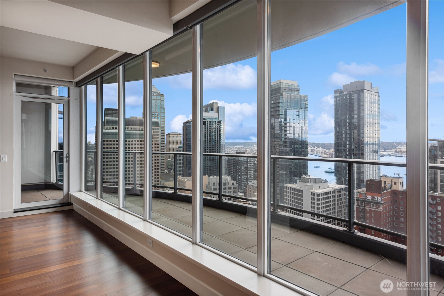 1920 4th Avenue, Unit 2702 Seattle, WA 98101 - Photo 5 of 40 a view of a balcony with a floor to ceiling window and wooden floor