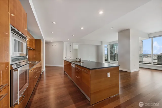 a large kitchen with stainless steel appliances granite countertop a large counter top a stove and a refrigerator