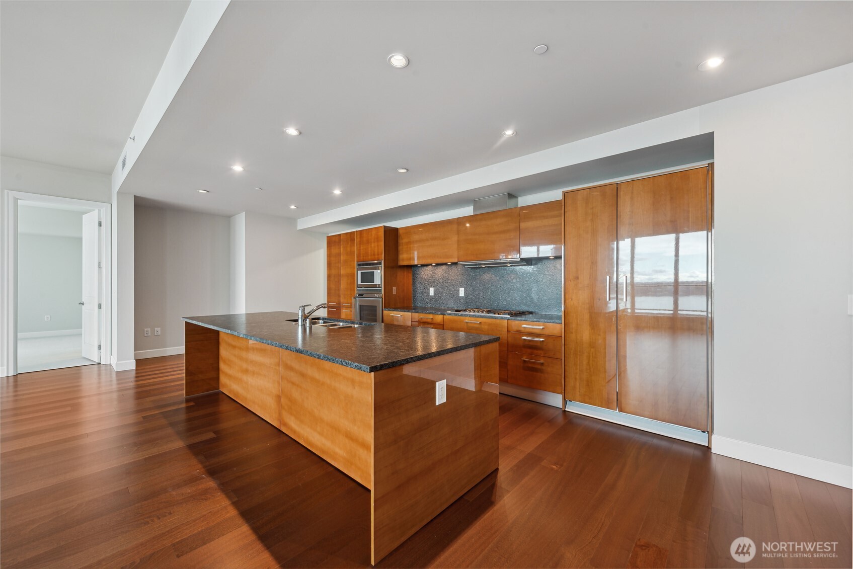 1920 4th Avenue, Unit 2702 Seattle, WA 98101 - Photo 9 of 40 a view of living room with kitchen island granite countertop wooden floor and a large window