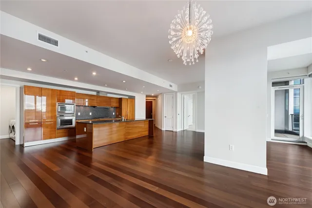 an empty room with wooden floor and large windows