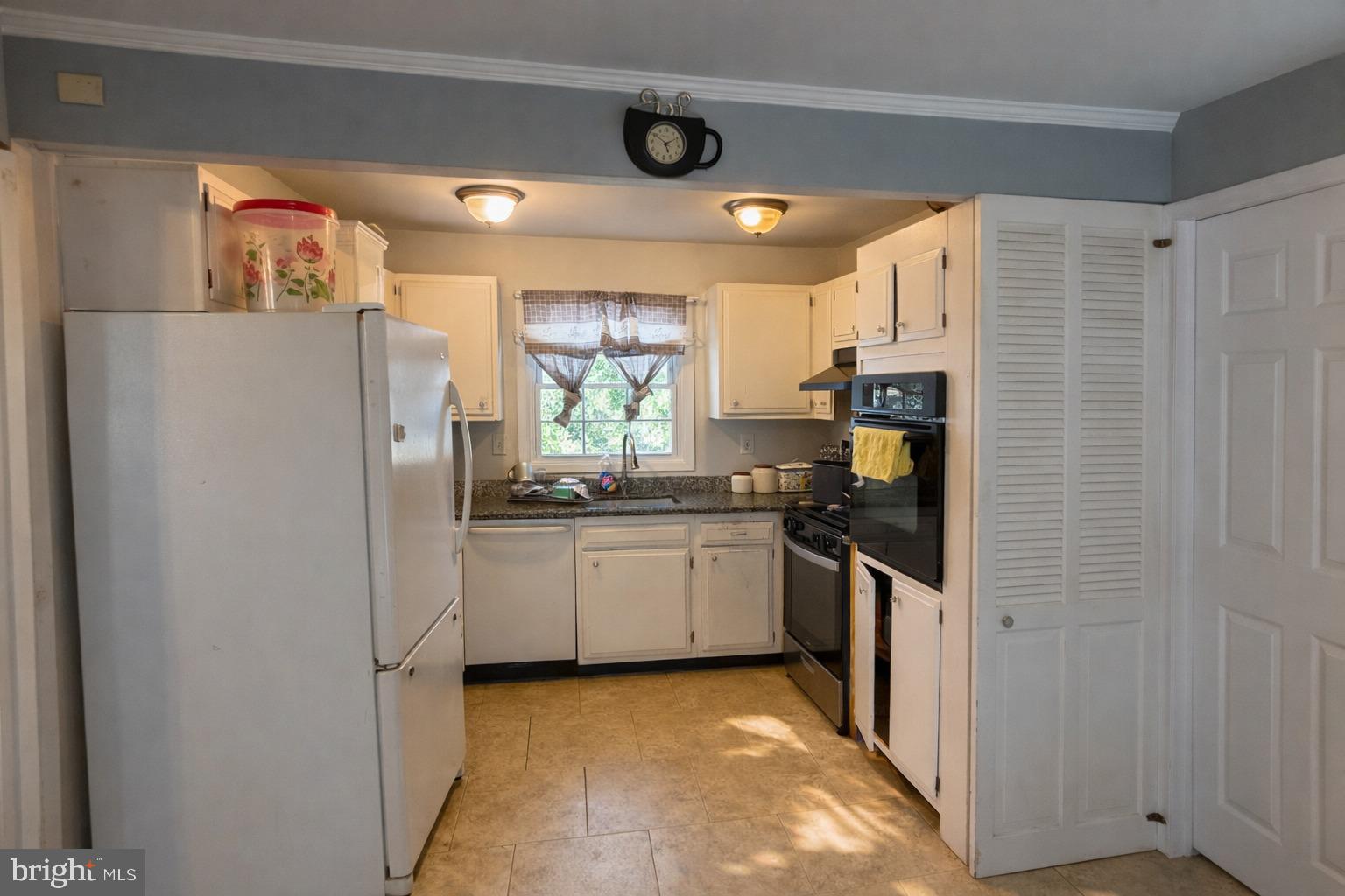 12600 Cedarbrook Lane Laurel, MD 20708 - Photo 7 of 15 a kitchen with stainless steel appliances a refrigerator a sink and white cabinets