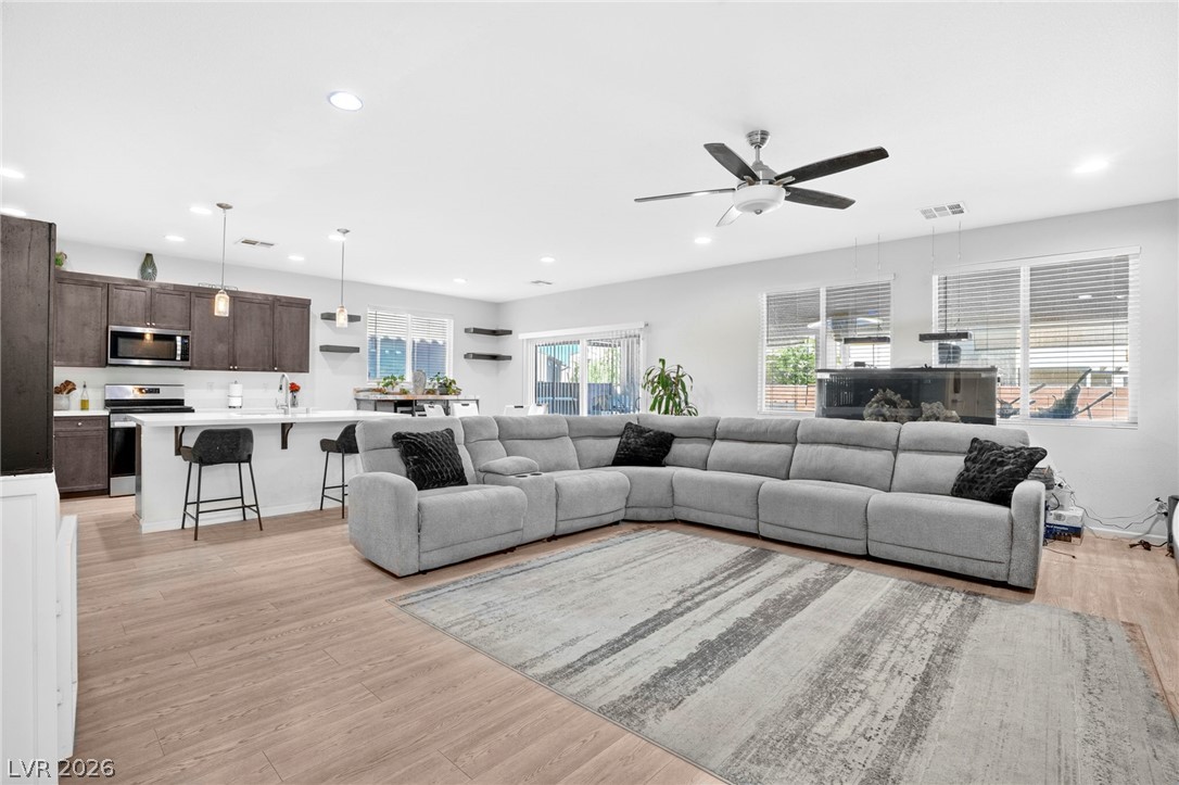 6281 Angora Peak Lane Las Vegas, NV 89115 - Photo 8 of 34 An open concept living area connects seamlessly to a modern kitchen, offering effortless flow.