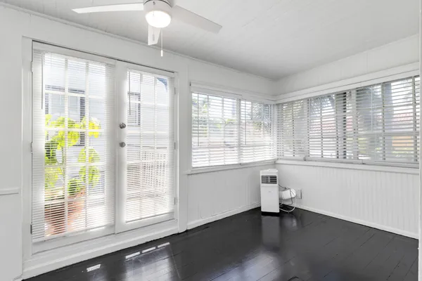 a view of an empty room with a window and wooden floor
