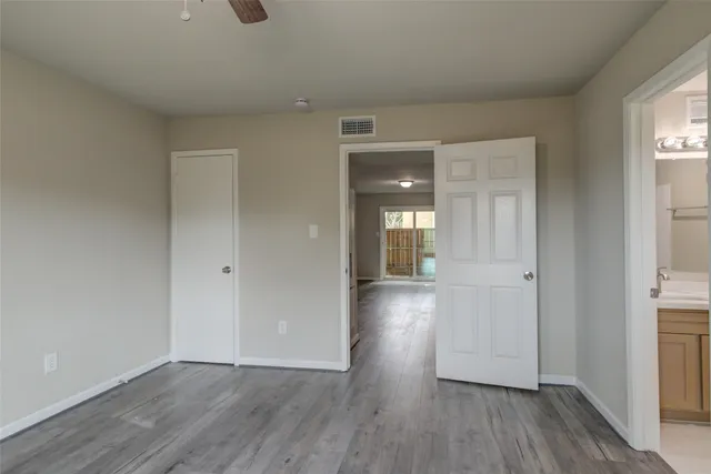 an empty room with closet and a chandelier fan