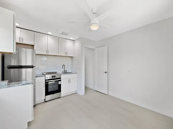 a kitchen with granite countertop a refrigerator oven a sink and dishwasher