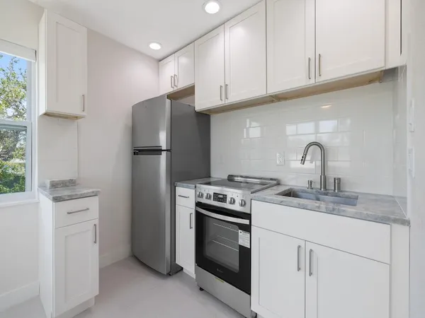 a kitchen with appliances a sink and cabinets