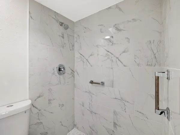 an empty room with windows and ceiling fan