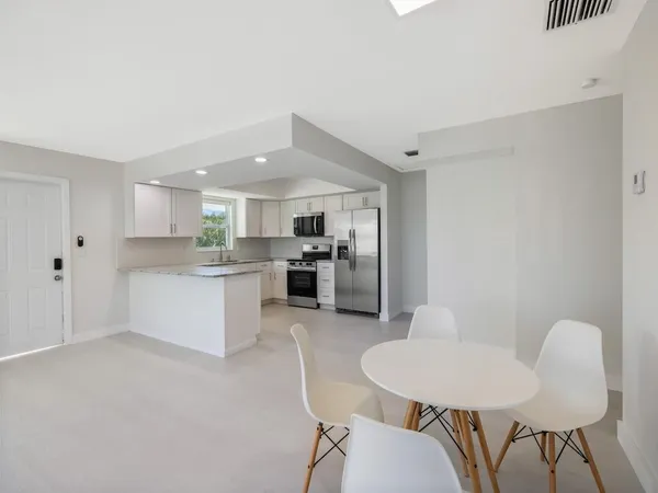 a kitchen with granite countertop white cabinets white stainless steel appliances with a sink and dishwasher
